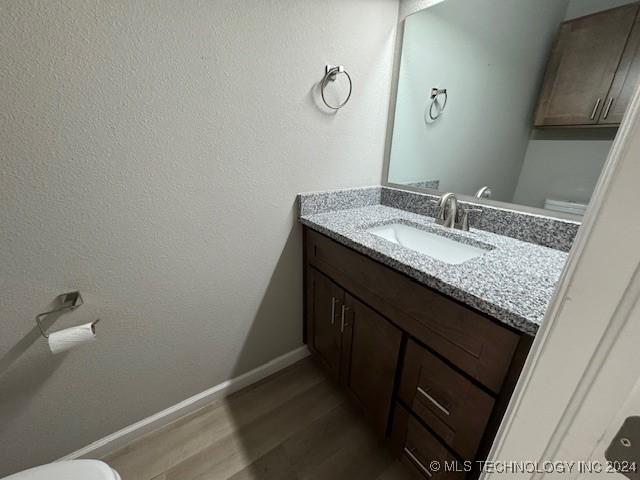 3402 Redbud Ln, Tulsa, OK 74132 - bathroom featuring toilet, vanity, wood finished floors, and baseboards