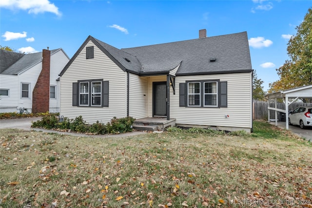 view of front of home with a front yard and a carport