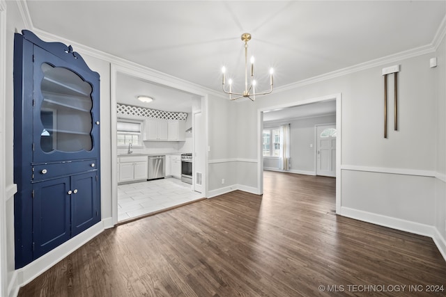 unfurnished dining area with sink, hardwood / wood-style flooring, ornamental molding, and a notable chandelier