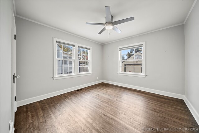 empty room with ceiling fan, plenty of natural light, dark hardwood / wood-style flooring, and crown molding