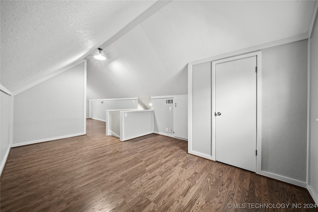 bonus room with hardwood / wood-style floors, a textured ceiling, and vaulted ceiling