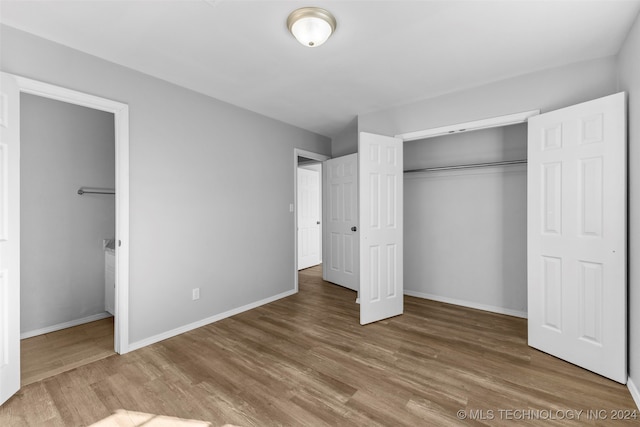 unfurnished bedroom featuring wood-type flooring and a closet