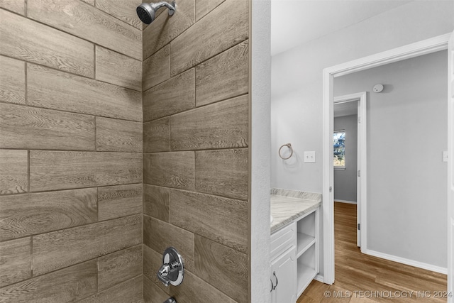 bathroom with vanity, hardwood / wood-style floors, and  shower combination