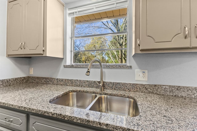 kitchen with light stone countertops and sink