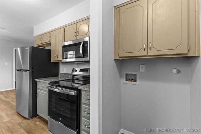 kitchen with light stone counters, light hardwood / wood-style flooring, and appliances with stainless steel finishes