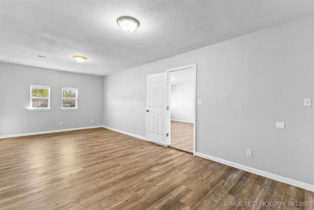 empty room featuring hardwood / wood-style flooring and a textured ceiling