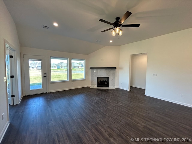 unfurnished living room with dark hardwood / wood-style flooring, lofted ceiling, a tile fireplace, and ceiling fan