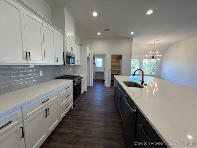 kitchen featuring stainless steel appliances, white cabinetry, dark hardwood / wood-style flooring, pendant lighting, and a chandelier