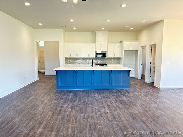 kitchen with a kitchen island with sink, white cabinetry, and dark wood-type flooring