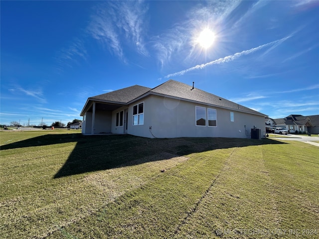 view of home's exterior with central air condition unit and a lawn