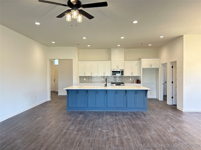 kitchen with white cabinetry, tasteful backsplash, ceiling fan, dark hardwood / wood-style floors, and a large island