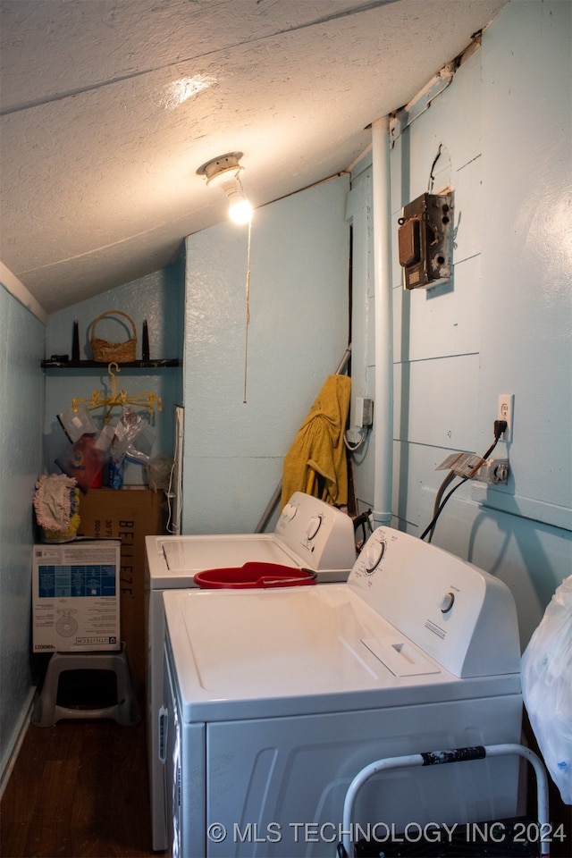 laundry room with wood-type flooring, washer and dryer, and a textured ceiling