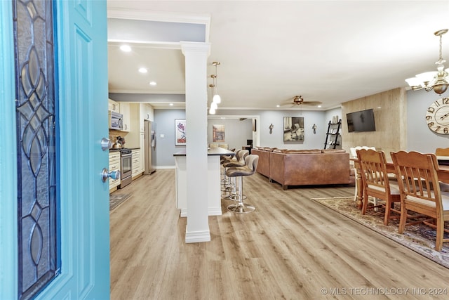 interior space with ornamental molding, decorative columns, ceiling fan, and light hardwood / wood-style floors