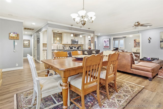 dining space featuring ceiling fan with notable chandelier, light hardwood / wood-style flooring, and ornamental molding