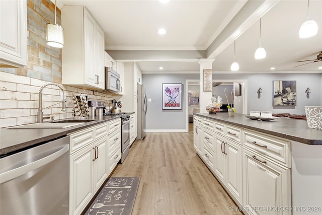 kitchen with white cabinets, decorative columns, pendant lighting, light wood-type flooring, and appliances with stainless steel finishes