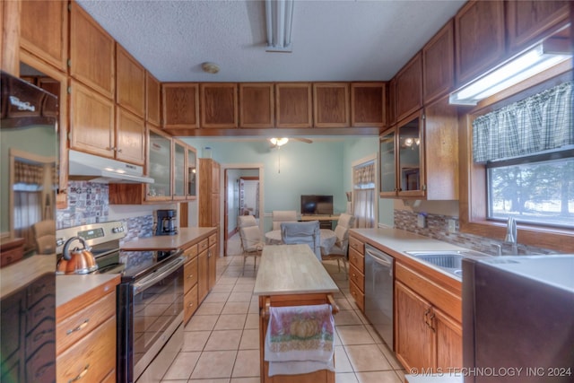 15705 Old Morris Hwy, Okmulgee, OK 74447 - kitchen featuring stainless steel appliances, under cabinet range hood, light countertops, a sink, and a textured ceiling