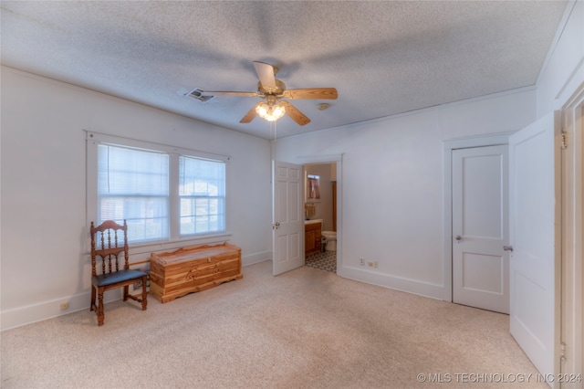 living area with a textured ceiling, ceiling fan, and light carpet