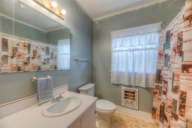 bathroom with heating unit, vanity, a healthy amount of sunlight, and toilet