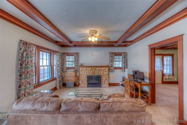 carpeted living room featuring ceiling fan, a fireplace, crown molding, and a textured ceiling