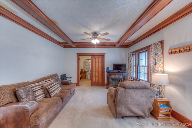 carpeted living room with ceiling fan, ornamental molding, and a textured ceiling