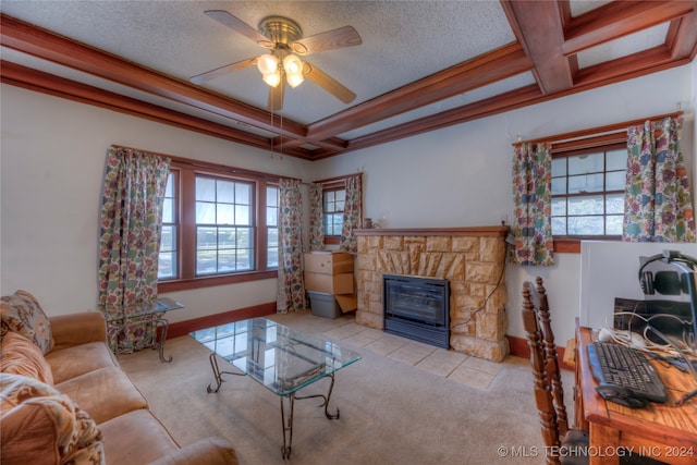 carpeted living room with ceiling fan, a healthy amount of sunlight, a stone fireplace, and ornamental molding