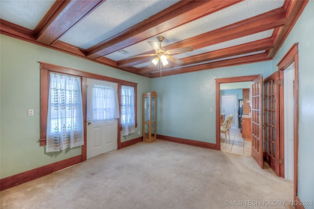 carpeted foyer featuring ceiling fan, beam ceiling, and a textured ceiling