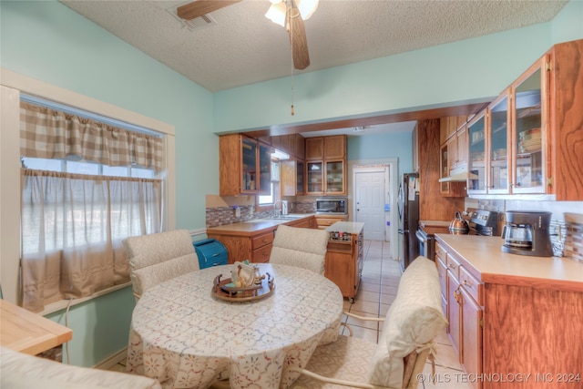 dining room with light tile patterned floors, a textured ceiling, ceiling fan, and sink