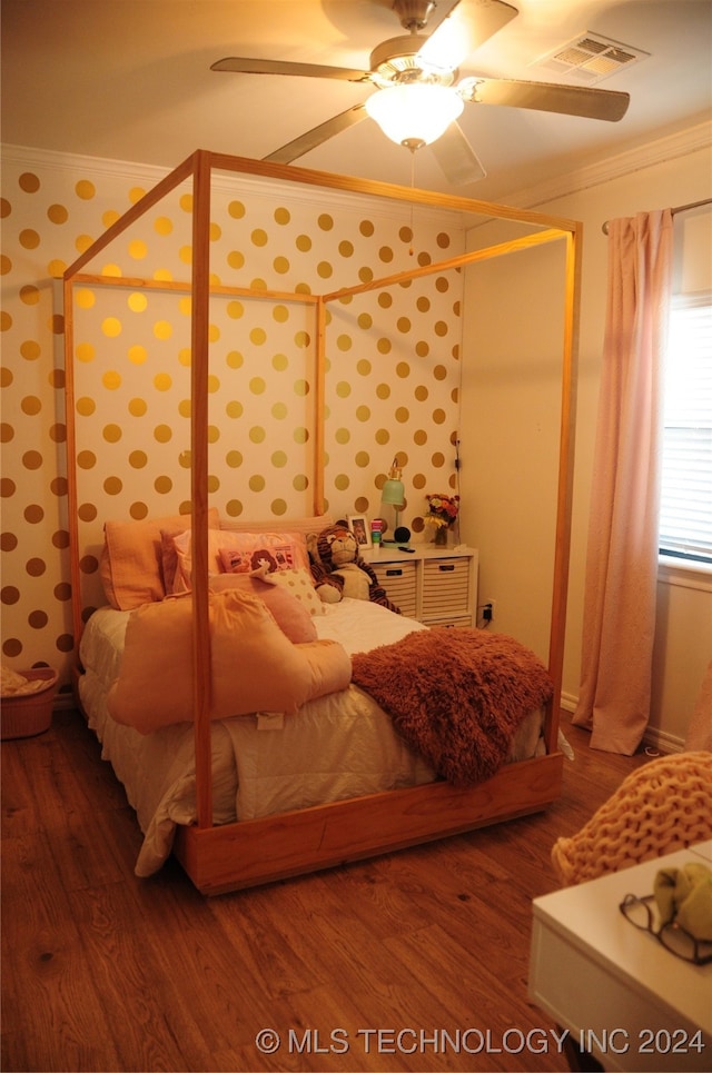 bedroom with dark hardwood / wood-style flooring, ornamental molding, and ceiling fan