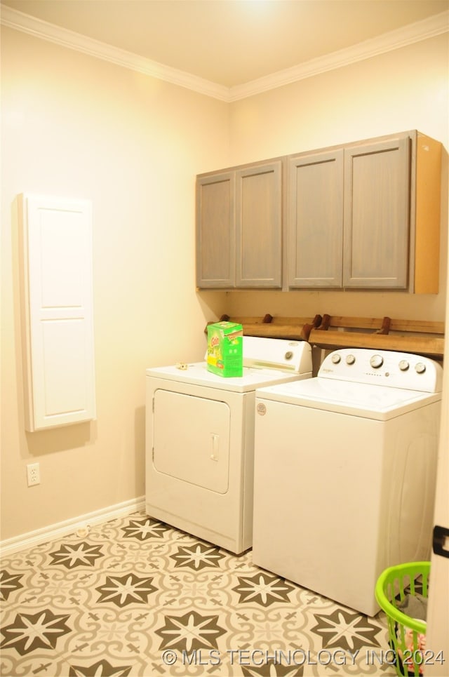 laundry area with washing machine and dryer, cabinets, crown molding, and light tile patterned floors