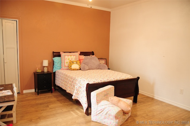 bedroom featuring ornamental molding and light hardwood / wood-style flooring