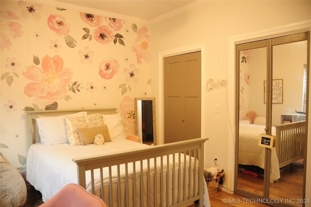 bedroom with a closet, wood-type flooring, and crown molding