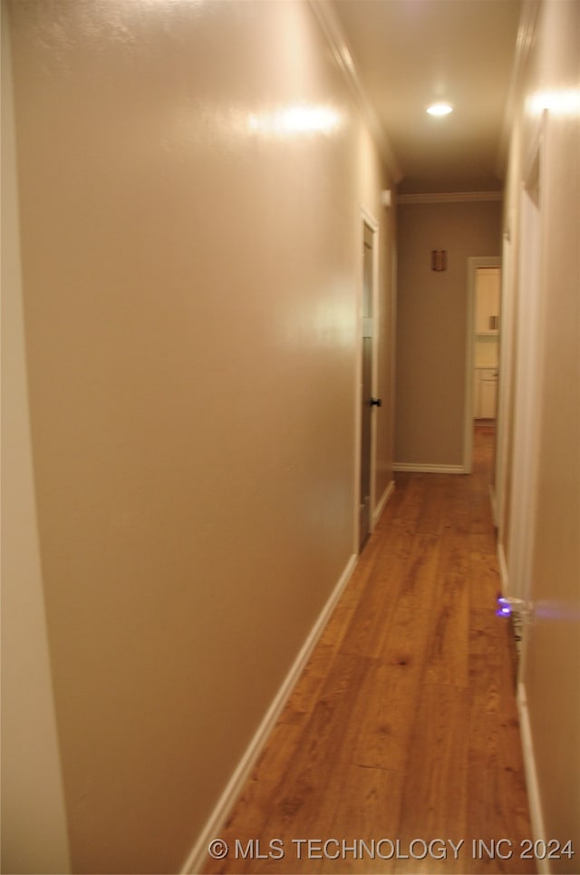 corridor featuring hardwood / wood-style floors and crown molding