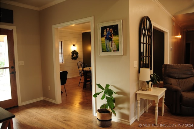 hallway with ornamental molding and light wood-type flooring