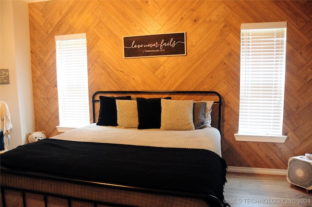 bedroom featuring wood-type flooring and wooden walls