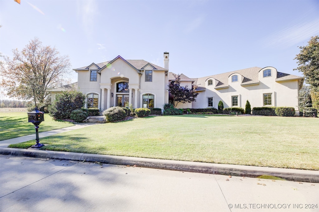 french provincial home featuring a front lawn