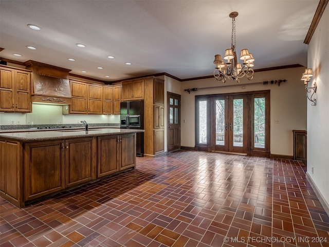 kitchen featuring sink, hanging light fixtures, ornamental molding, black fridge with ice dispenser, and a chandelier