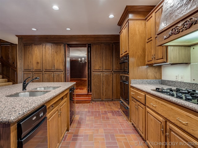 kitchen with sink, light stone counters, backsplash, black appliances, and custom exhaust hood