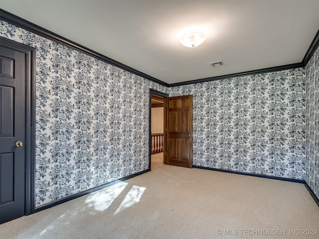 carpeted spare room featuring crown molding