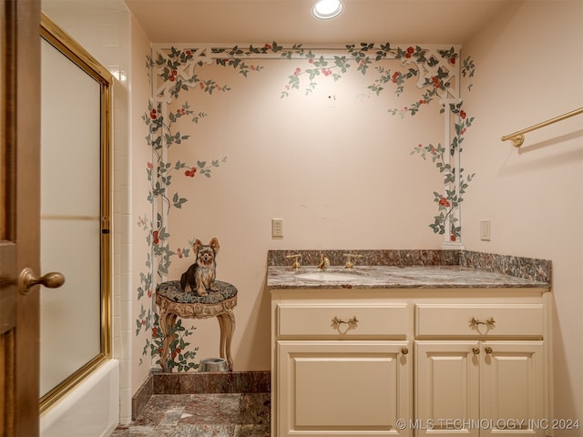 bathroom with combined bath / shower with glass door and vanity