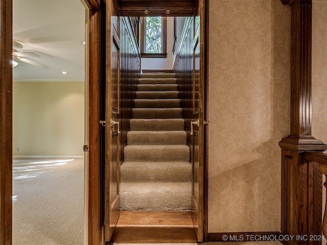 stairway featuring hardwood / wood-style flooring, ceiling fan, and crown molding