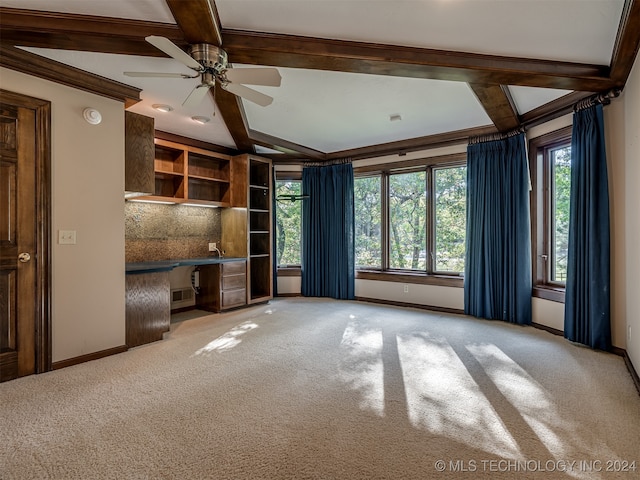 unfurnished living room with carpet, beam ceiling, and ceiling fan