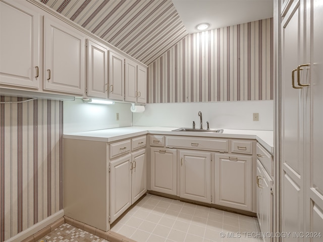 laundry area featuring light tile patterned flooring and sink