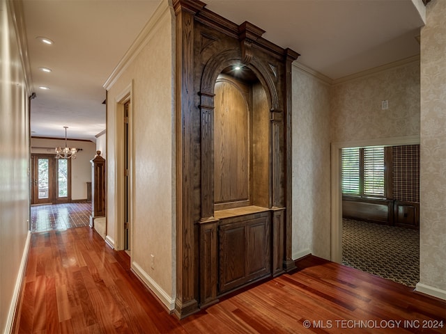 corridor featuring a chandelier, french doors, ornamental molding, and hardwood / wood-style flooring