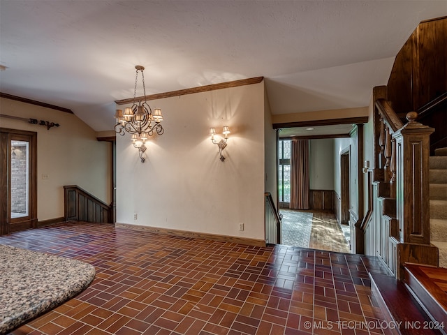 interior space featuring an inviting chandelier, crown molding, and vaulted ceiling