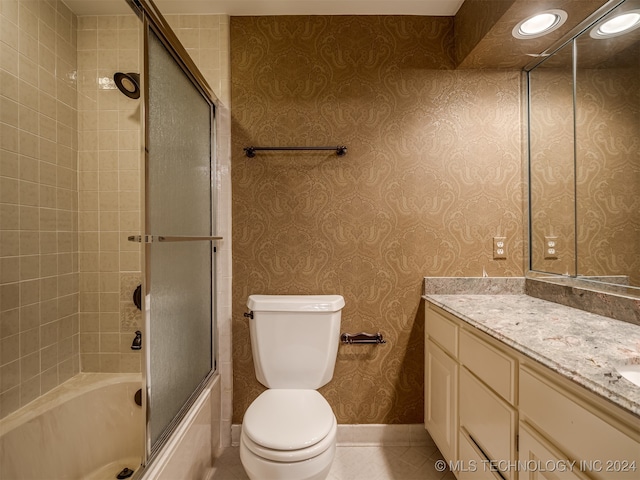 full bathroom with tile patterned flooring, combined bath / shower with glass door, toilet, and vanity