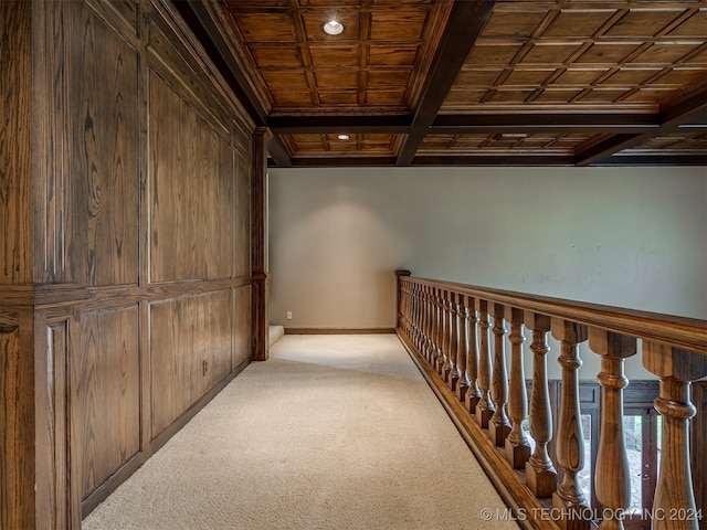 hallway with beamed ceiling, wooden ceiling, light carpet, and coffered ceiling