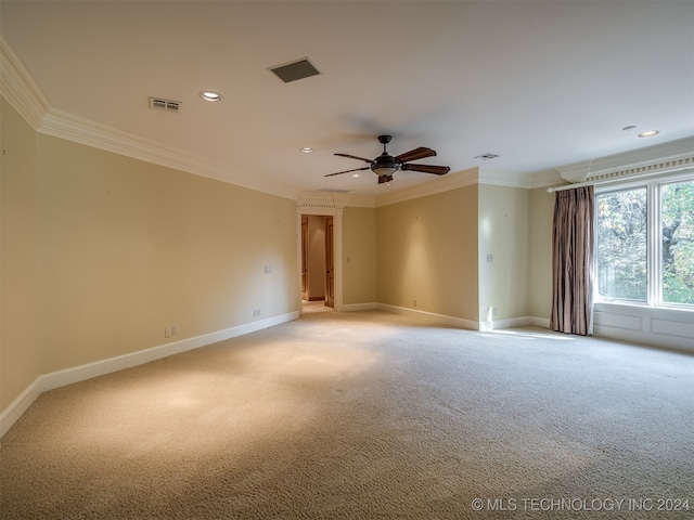 spare room featuring ceiling fan, light colored carpet, and ornamental molding