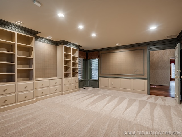 cinema room featuring carpet flooring, built in shelves, and crown molding