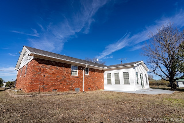 back of property with a yard and a patio area