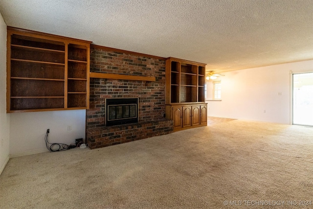 815 S Oak Grove Rd, Cushing, OK 74023 - unfurnished living room featuring carpet flooring, a fireplace, a textured ceiling, and a ceiling fan